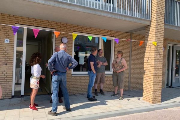 Vlaggetjes hangen voor de deuren van het opgeleverde complex de Ankerplaats in Muiden