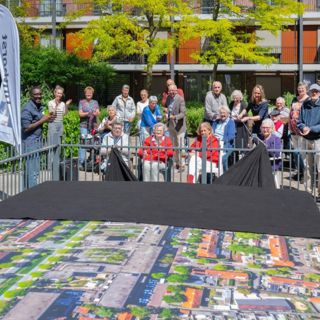 Het doek wordt van het transformatorhuisje getrokken tijdens de onthulling van de luchtfoto