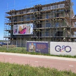 Woontoren in steigers met G&O banners 