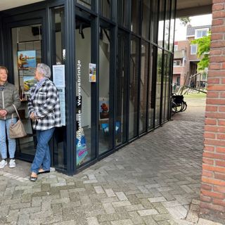Twee vrouwen voor een appartementengebouw