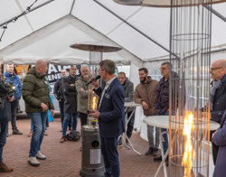 man houdt praatje in grote tent