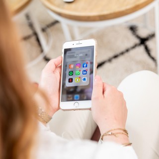 Jonge vrouw op bank met telefoon in hand